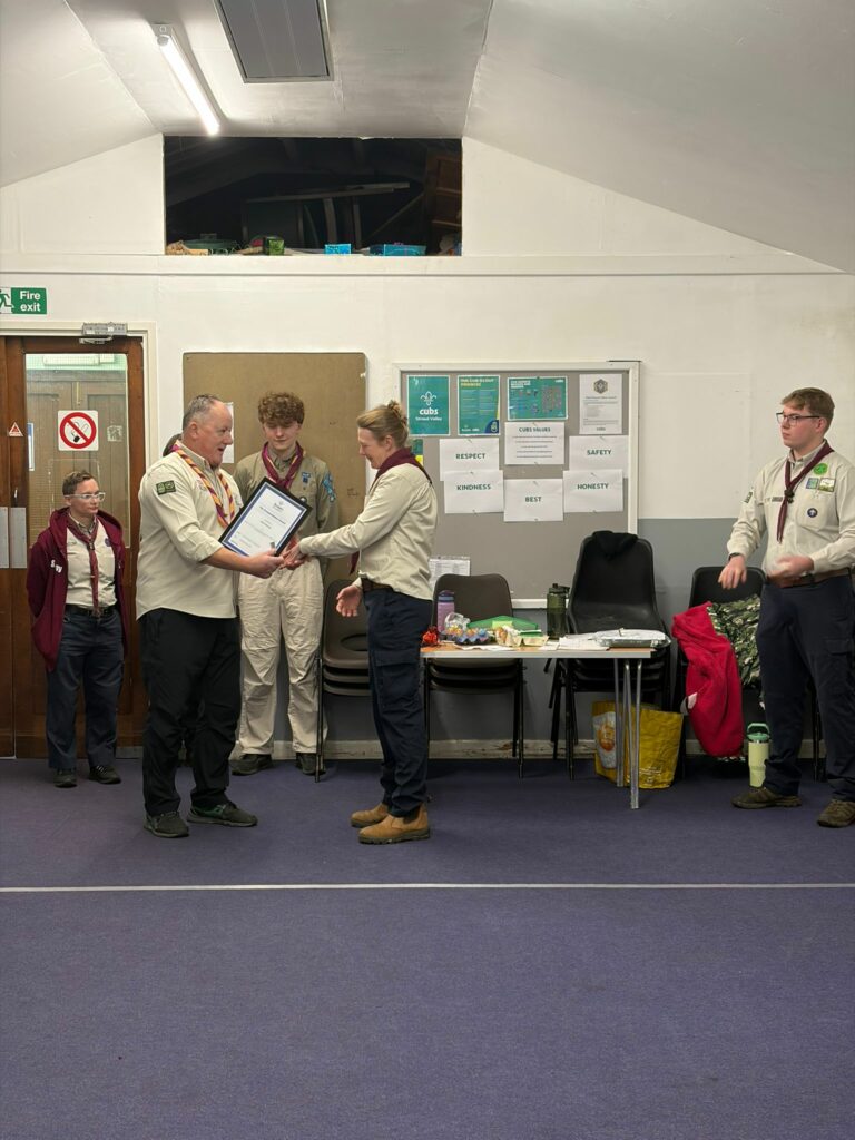 A Leader being invested and receiving a commendation award during a ceremony at Stroud Valley Scout Group