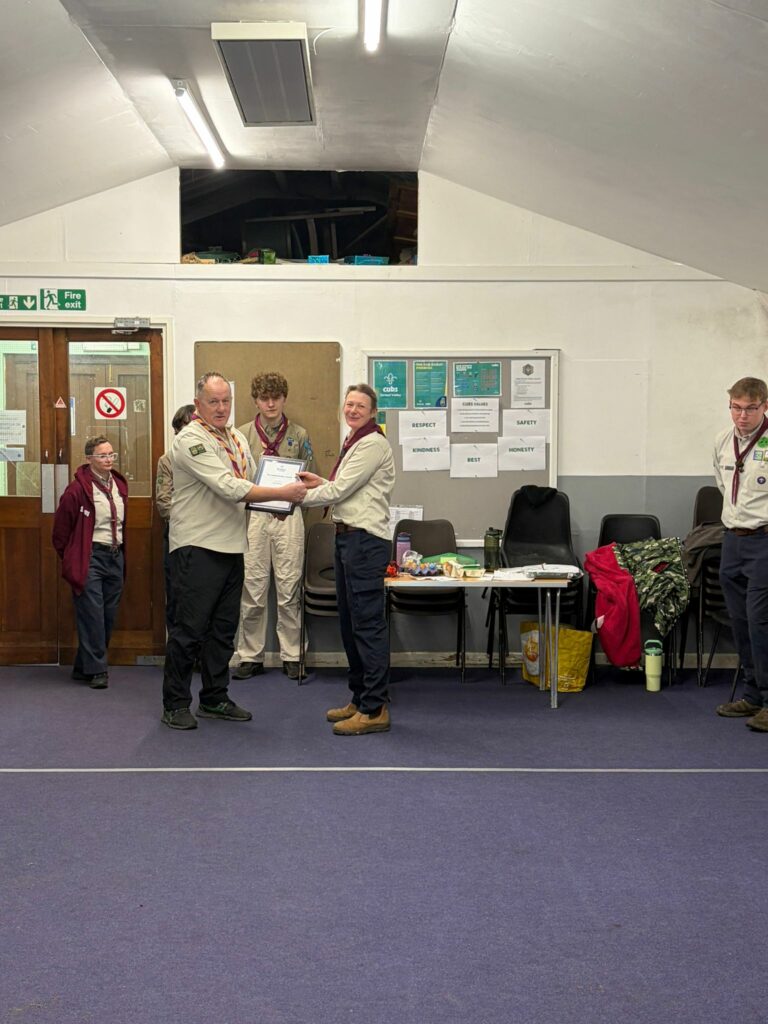 A Leader being invested and receiving a commendation award during a ceremony at Stroud Valley Scout Group