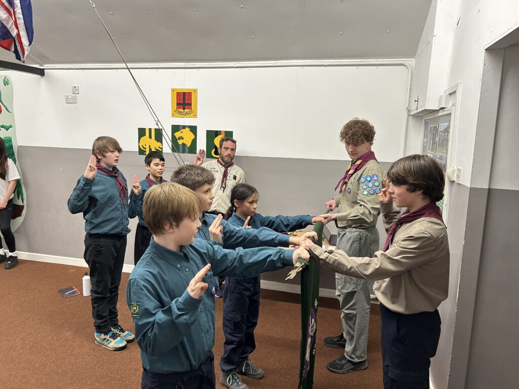 Scouts taking part in an investiture ceremony and making their Scout Promise at Stroud Valley Scout Group